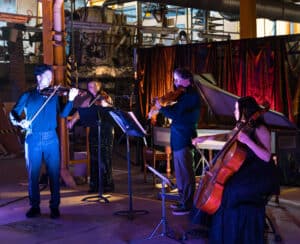 Basement Baroque musicians performing in the darkened Paint Factory 'basement.'