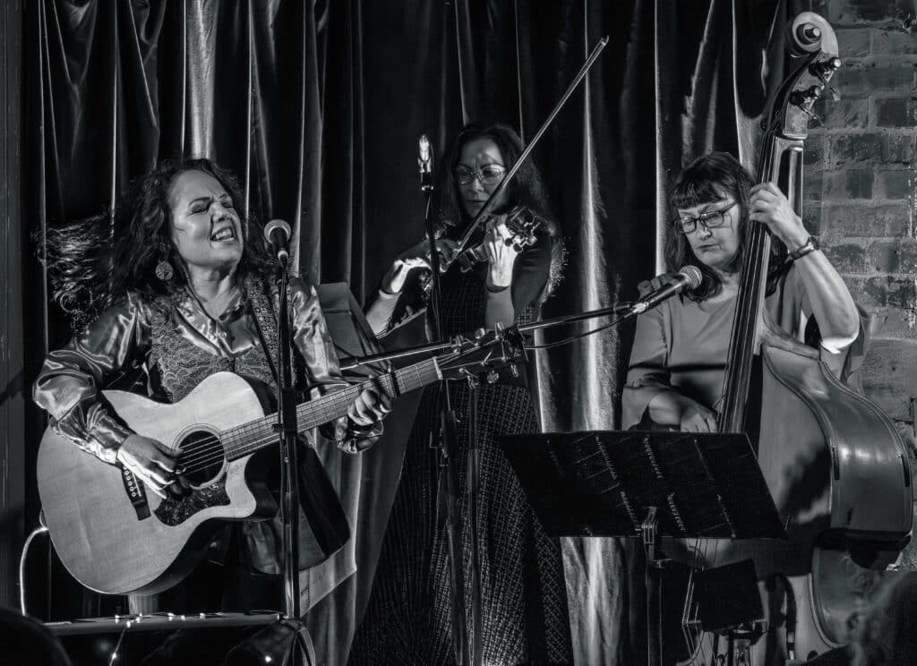 B&W photo of Ruth Apelt, and two string musicians