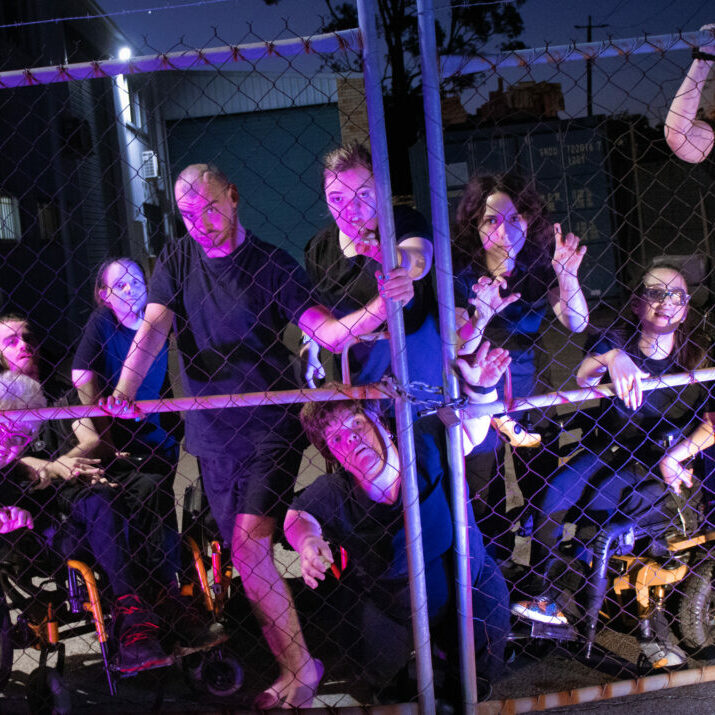 A group of people behind a wire fence