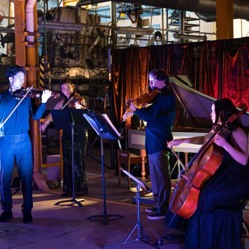 Basement Baroque musicians performing in the darkened Paint Factory 'basement.'